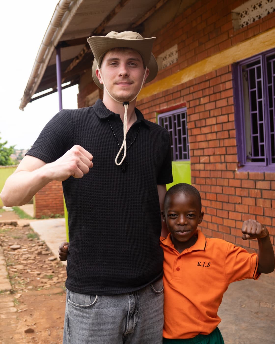 Victoria-Mitgründer mit einem Jungen der Kisa Foundation vor der Schule in Uganda